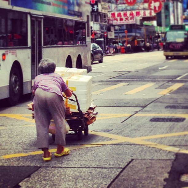 An-hunched-old-lady-pushes-her-cart-of-recyclables-hongkong